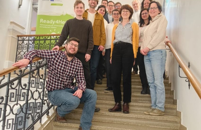 10 Personen posieren auf Stiege vor dem ready four heat banner und lächeln