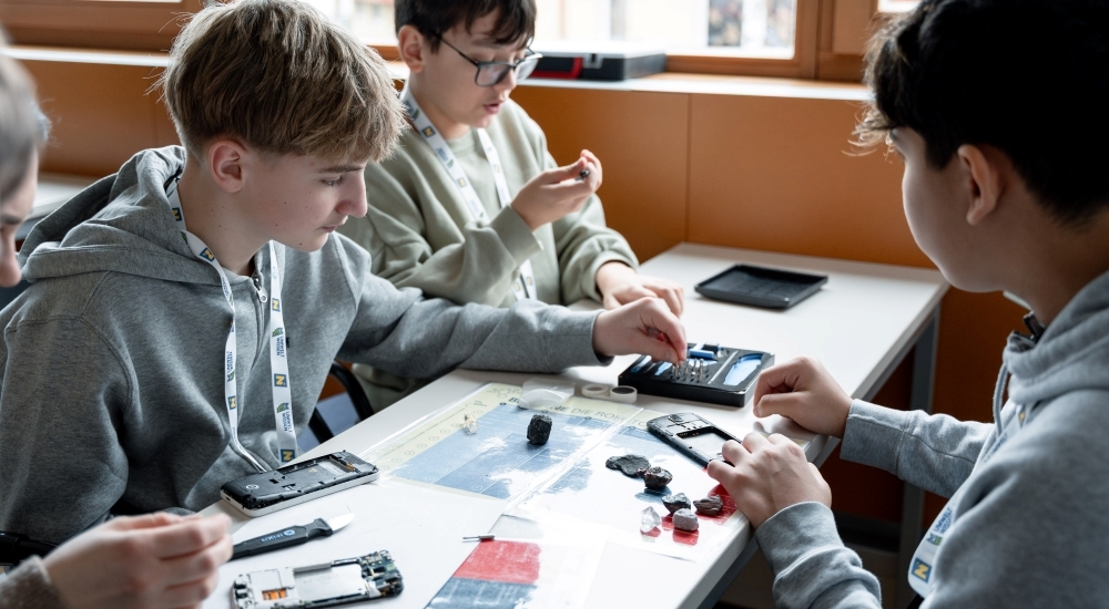 drei jugendliche Jungen handwerken mit alten Handys