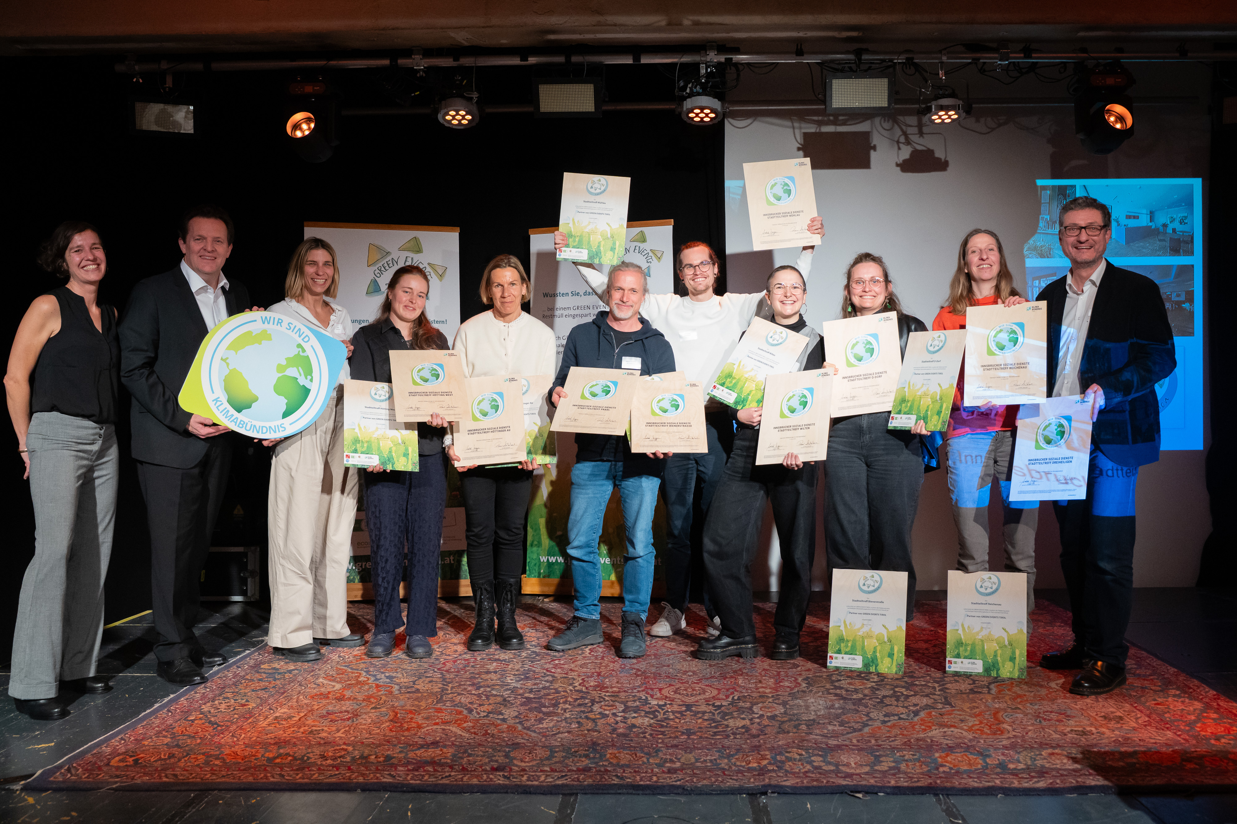 Gruppe von Menschen auf einer Bühne mit Urkunden für nachhaltige Veranstaltungen
