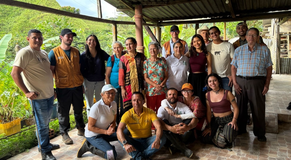 Gruppenbild von ungefähr zwanzig Menschen die in die Kamera lächeln
