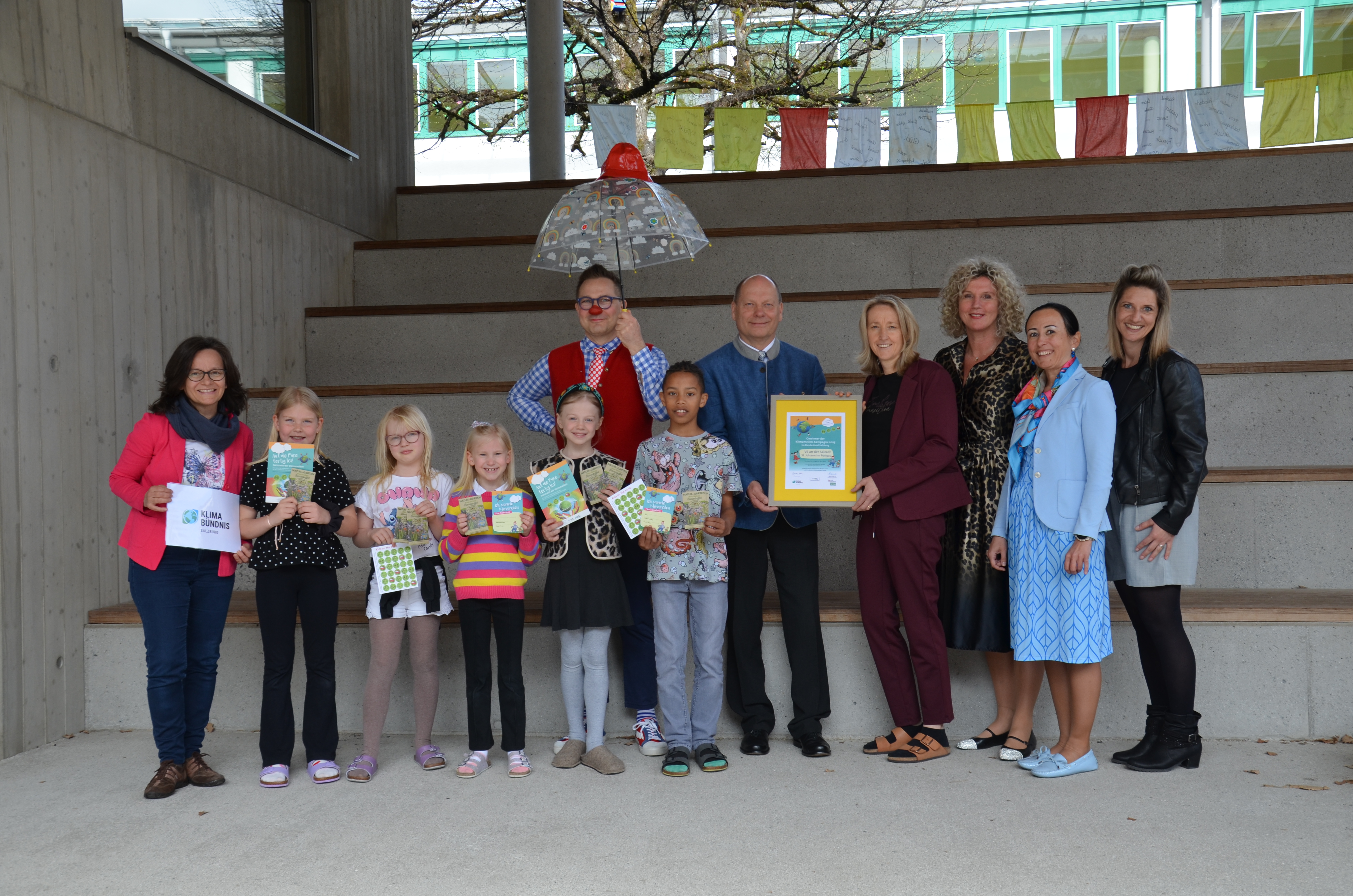 Gruppe von Ehrengästen und Kindern mit Siegerurkunde Klimameilen