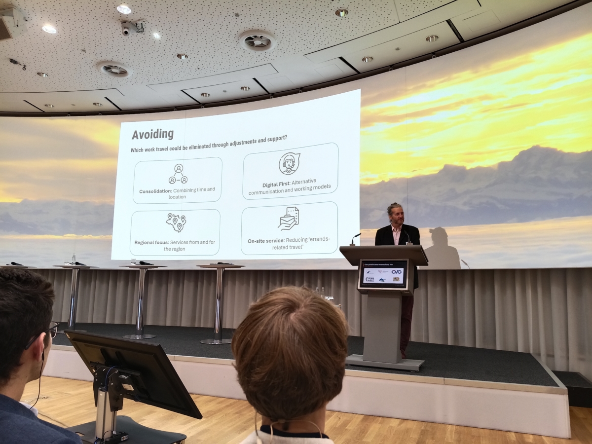Ein Mann am Rednerpult, im Hintergrund eine Präsentation